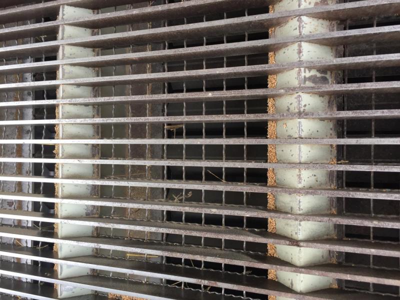 Pit grate with dust baffles and steel grid to catch foreign objects